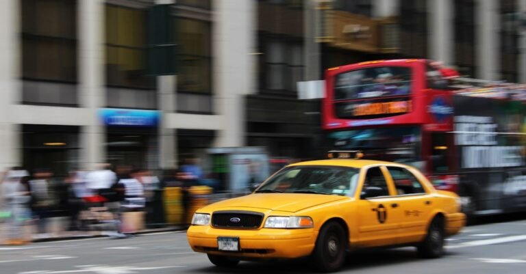 A yellow taxi speeds through the vibrant streets of New York City, capturing urban life and motion.
